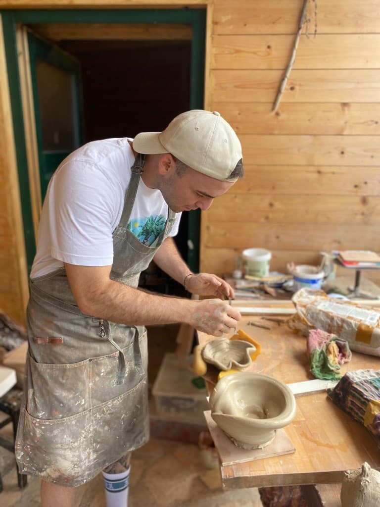 Artist hand-building clay pieces