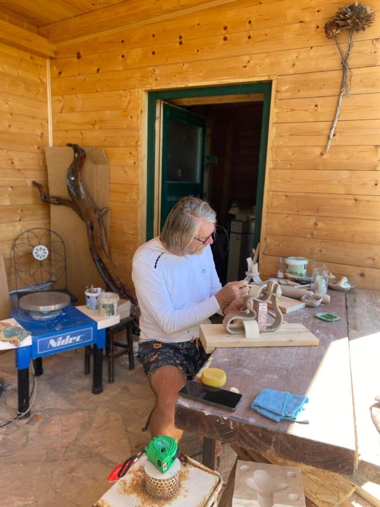 Artist sculpting at the workbench